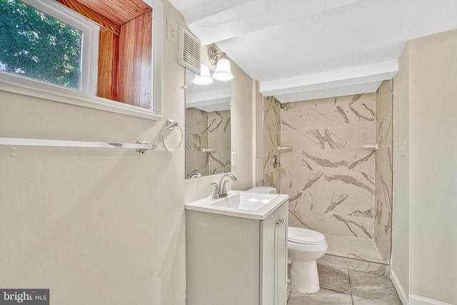 bathroom with tiled shower, toilet, and vanity