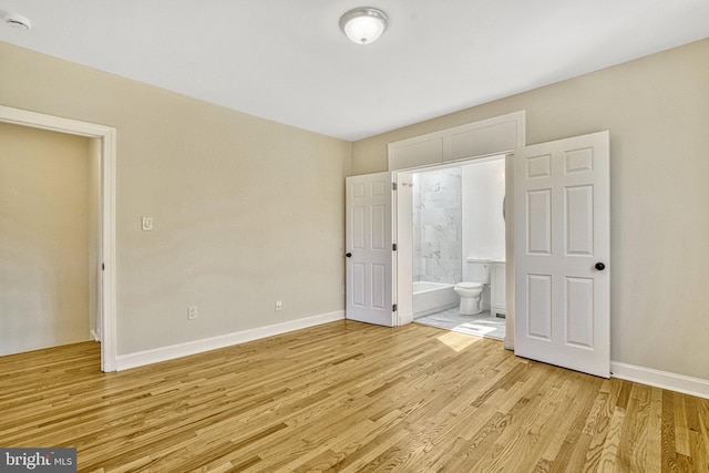 unfurnished bedroom with light hardwood / wood-style flooring and ensuite bath