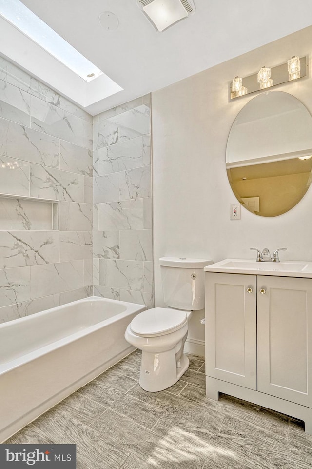 full bathroom with vanity, toilet, tiled shower / bath combo, and a skylight