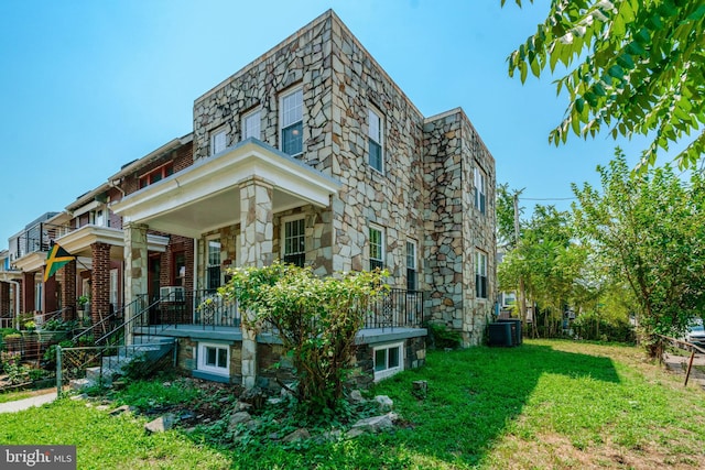 exterior space featuring a front lawn and central AC unit