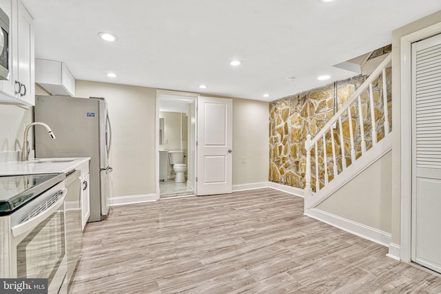 kitchen with white cabinetry, light hardwood / wood-style flooring, sink, and white electric range oven