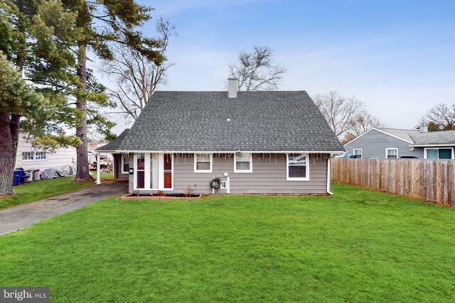 rear view of property featuring a yard