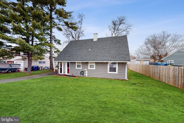 rear view of house featuring a yard