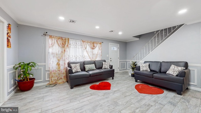 living room with ornamental molding and light hardwood / wood-style floors