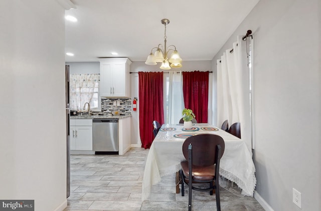 dining area with sink and a notable chandelier