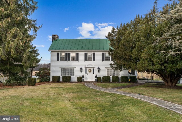 colonial inspired home with a front lawn