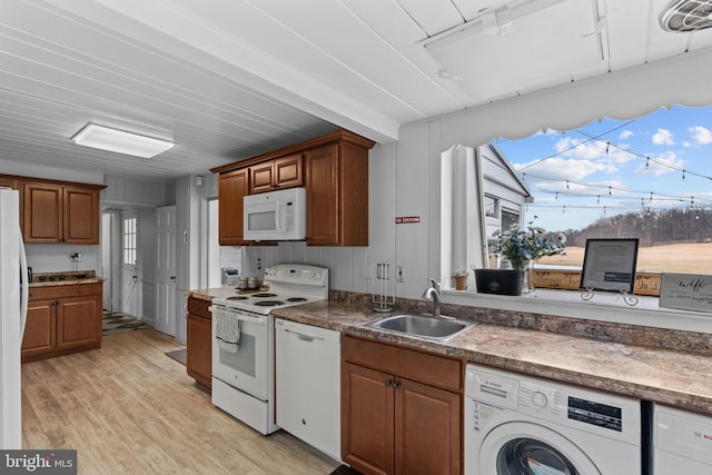 kitchen featuring sink, washer / dryer, light wood-type flooring, and white appliances