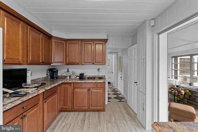 kitchen featuring light stone countertops and light wood-type flooring