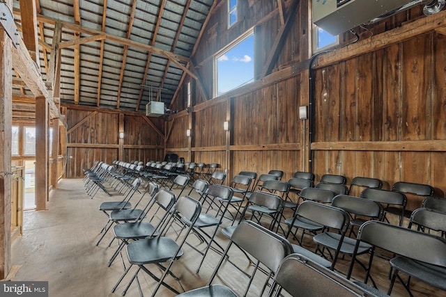 interior space featuring wooden walls and high vaulted ceiling