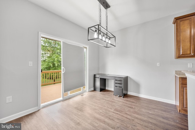 unfurnished dining area featuring hardwood / wood-style floors and an inviting chandelier