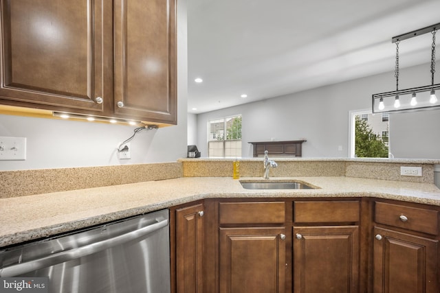 kitchen with sink, pendant lighting, dishwasher, and light stone countertops