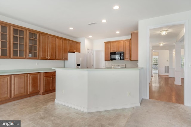 kitchen with range, white refrigerator with ice dispenser, and ornate columns