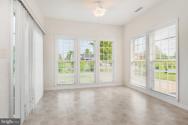 unfurnished sunroom with ceiling fan and a wealth of natural light