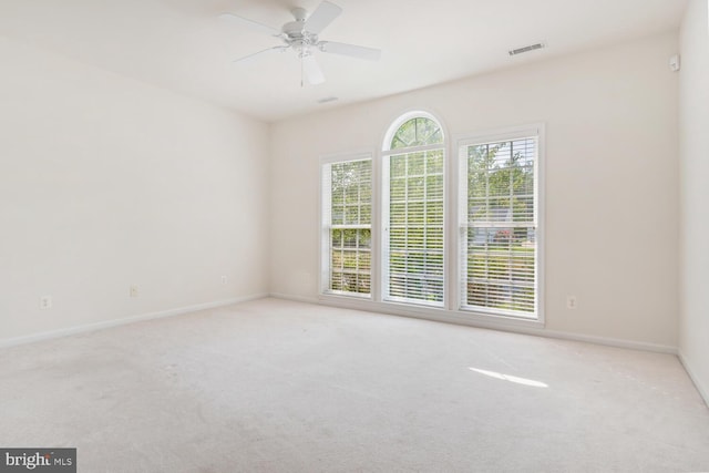 spare room with light colored carpet and ceiling fan