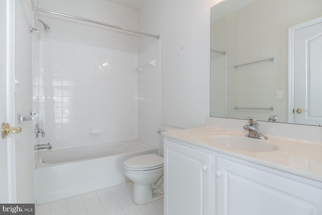 full bathroom with tile patterned flooring, tiled shower / bath, vanity, and toilet