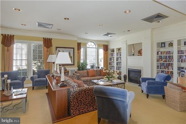 living room featuring built in shelves, ornamental molding, and light carpet