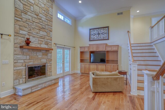 stairs with hardwood / wood-style floors, a towering ceiling, a fireplace, and french doors