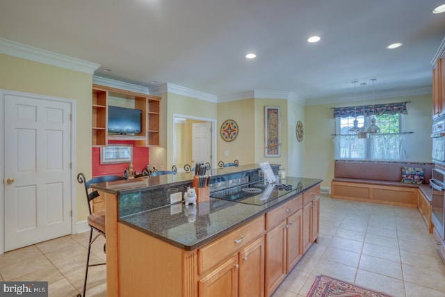 kitchen featuring a kitchen island, a breakfast bar, pendant lighting, light tile patterned floors, and black electric cooktop