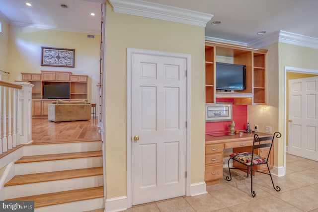 tiled office space featuring ornamental molding and built in desk