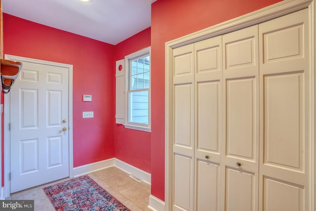 foyer entrance with baseboards and light tile patterned floors