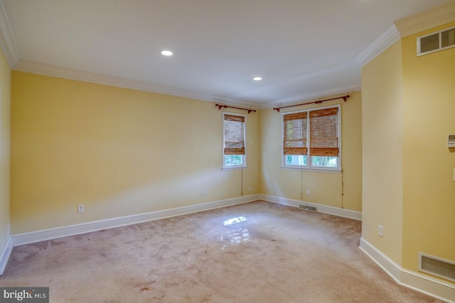 empty room featuring baseboards, visible vents, and ornamental molding