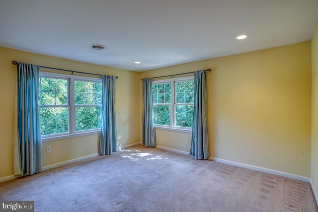 unfurnished room featuring recessed lighting, light colored carpet, visible vents, and baseboards