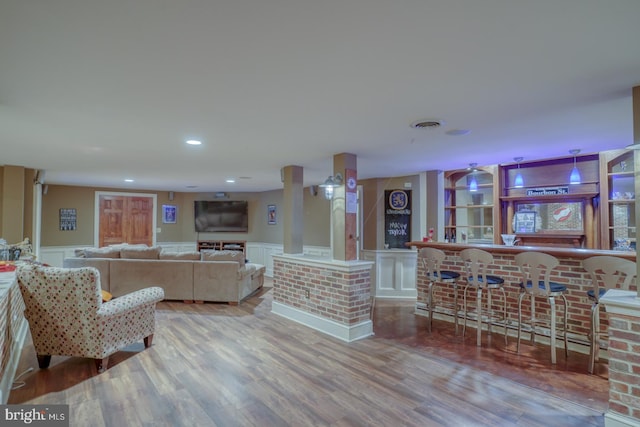 living room featuring wood-type flooring and bar area