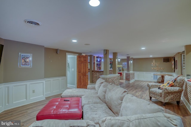 living room featuring light wood-style floors, wainscoting, visible vents, and recessed lighting