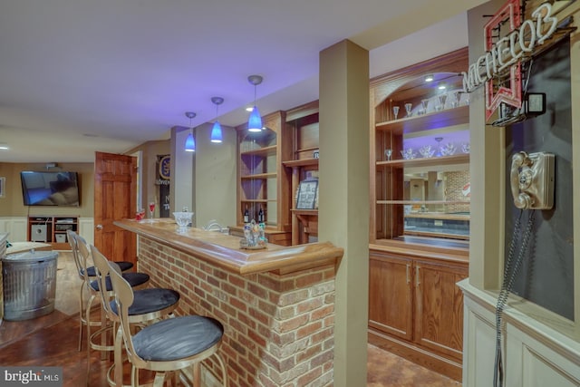 bar with hanging light fixtures and a dry bar