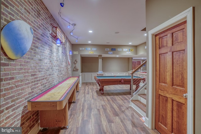 rec room featuring brick wall, wood finished floors, and recessed lighting