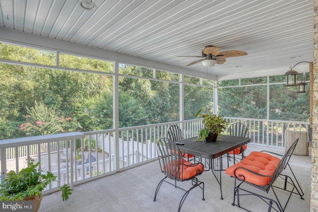 unfurnished sunroom featuring ceiling fan and a wealth of natural light