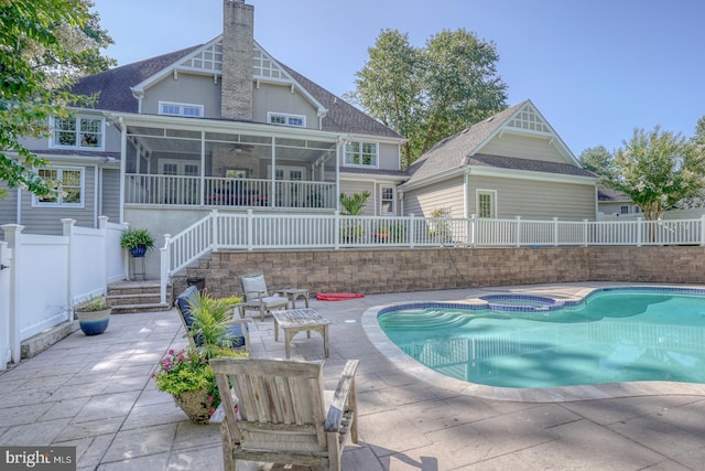 view of pool with a pool with connected hot tub, a ceiling fan, a sunroom, a patio area, and a fenced backyard