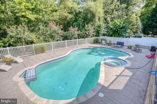 view of swimming pool with an in ground hot tub, a sunroom, and a patio area