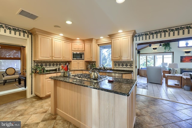 kitchen with recessed lighting, stainless steel appliances, visible vents, dark stone counters, and tasteful backsplash