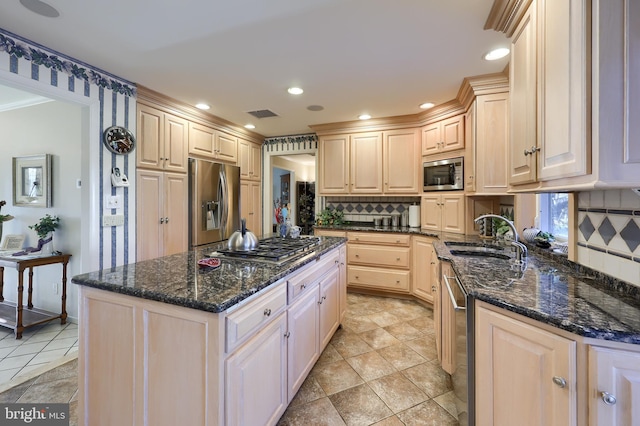 kitchen with stainless steel appliances, light brown cabinets, a sink, and backsplash