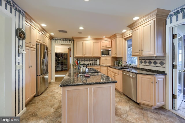 kitchen with visible vents, appliances with stainless steel finishes, decorative backsplash, and a center island