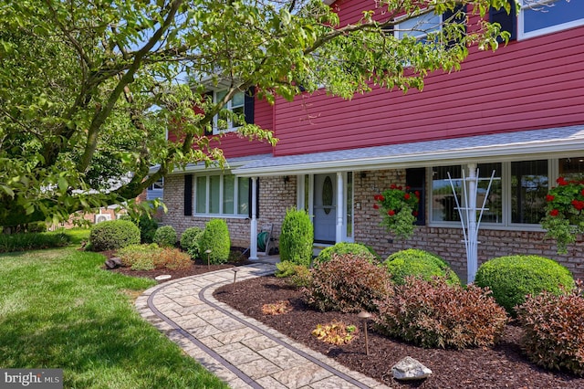 view of front of home featuring a shingled roof and a front yard