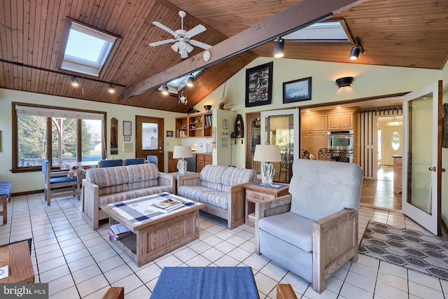 living area featuring a skylight, wood ceiling, track lighting, and light tile patterned flooring