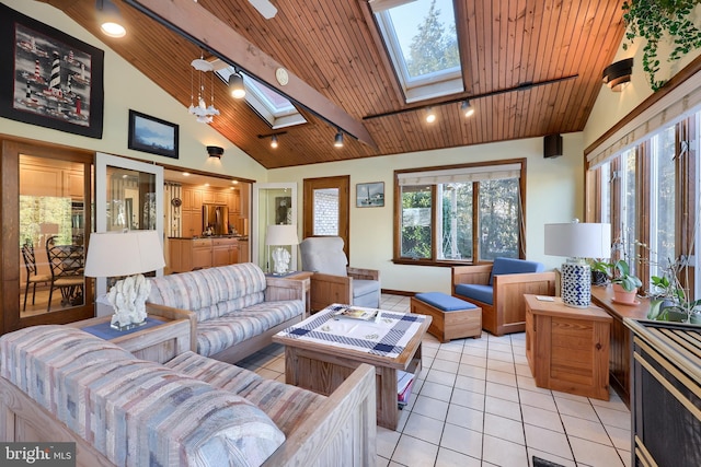 living area featuring high vaulted ceiling, light tile patterned flooring, wooden ceiling, a skylight, and rail lighting