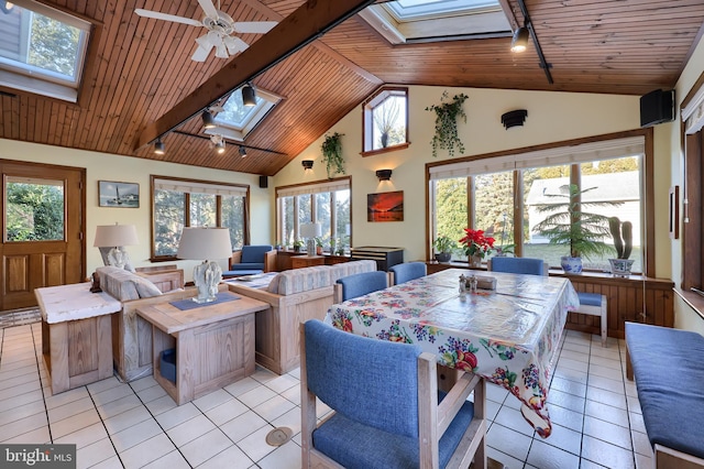 sunroom / solarium with a ceiling fan, vaulted ceiling with skylight, wood ceiling, and track lighting