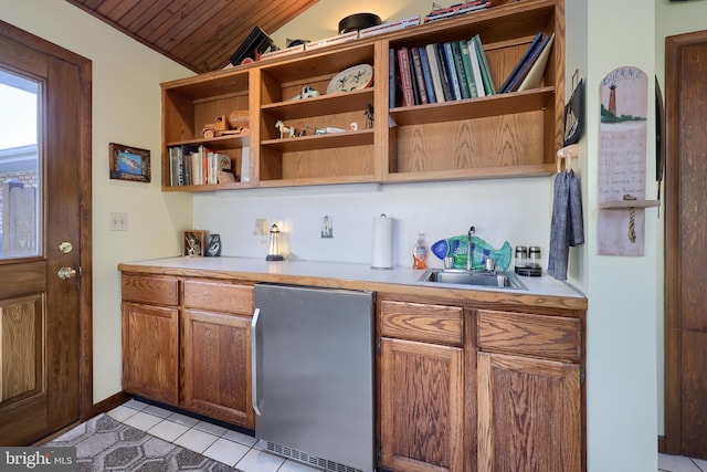 interior space with light tile patterned floors, wooden ceiling, a sink, vaulted ceiling, and freestanding refrigerator