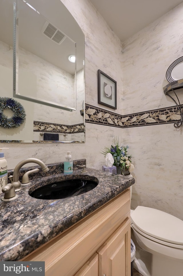 bathroom with visible vents, tile walls, toilet, vanity, and backsplash