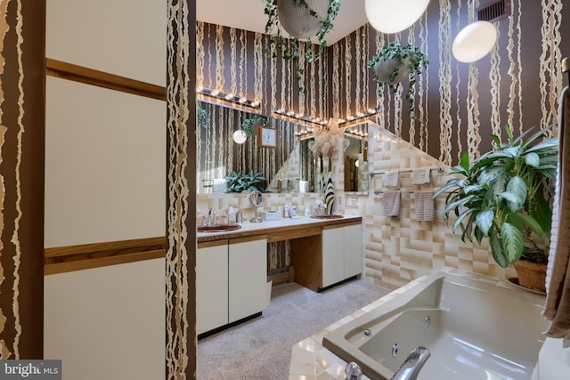 full bath featuring double vanity, visible vents, a tub with jets, and a sink