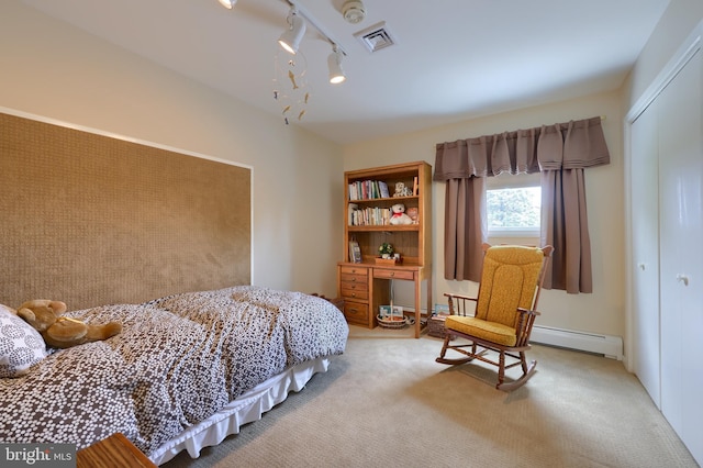 bedroom with visible vents, light colored carpet, rail lighting, baseboard heating, and a closet