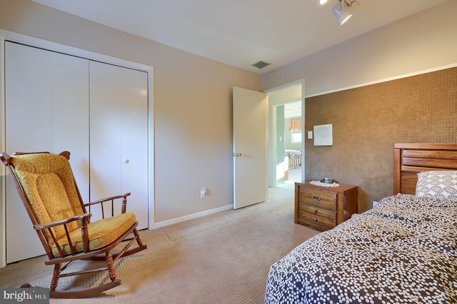 bedroom with light carpet, a closet, visible vents, and baseboards