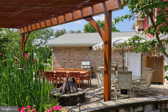 view of patio / terrace with an outdoor fire pit, outdoor dining area, and a pergola