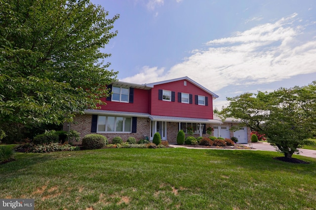 traditional home featuring a front lawn, brick siding, driveway, and an attached garage