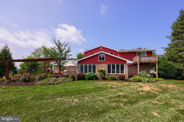 rear view of property with a deck, a lawn, and brick siding