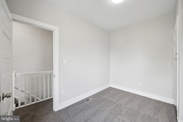 unfurnished room with dark colored carpet