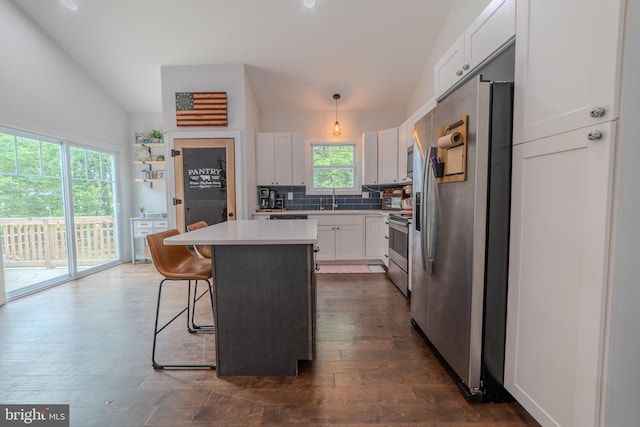 kitchen with pendant lighting, white cabinetry, a breakfast bar area, a center island, and stainless steel appliances